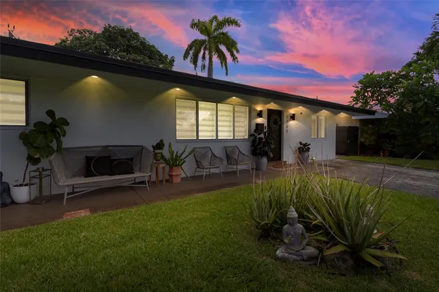 an aerial view of residential houses with outdoor space and trees