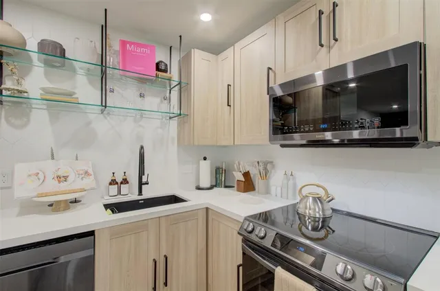a kitchen with stainless steel appliances a sink a stove and a microwave
