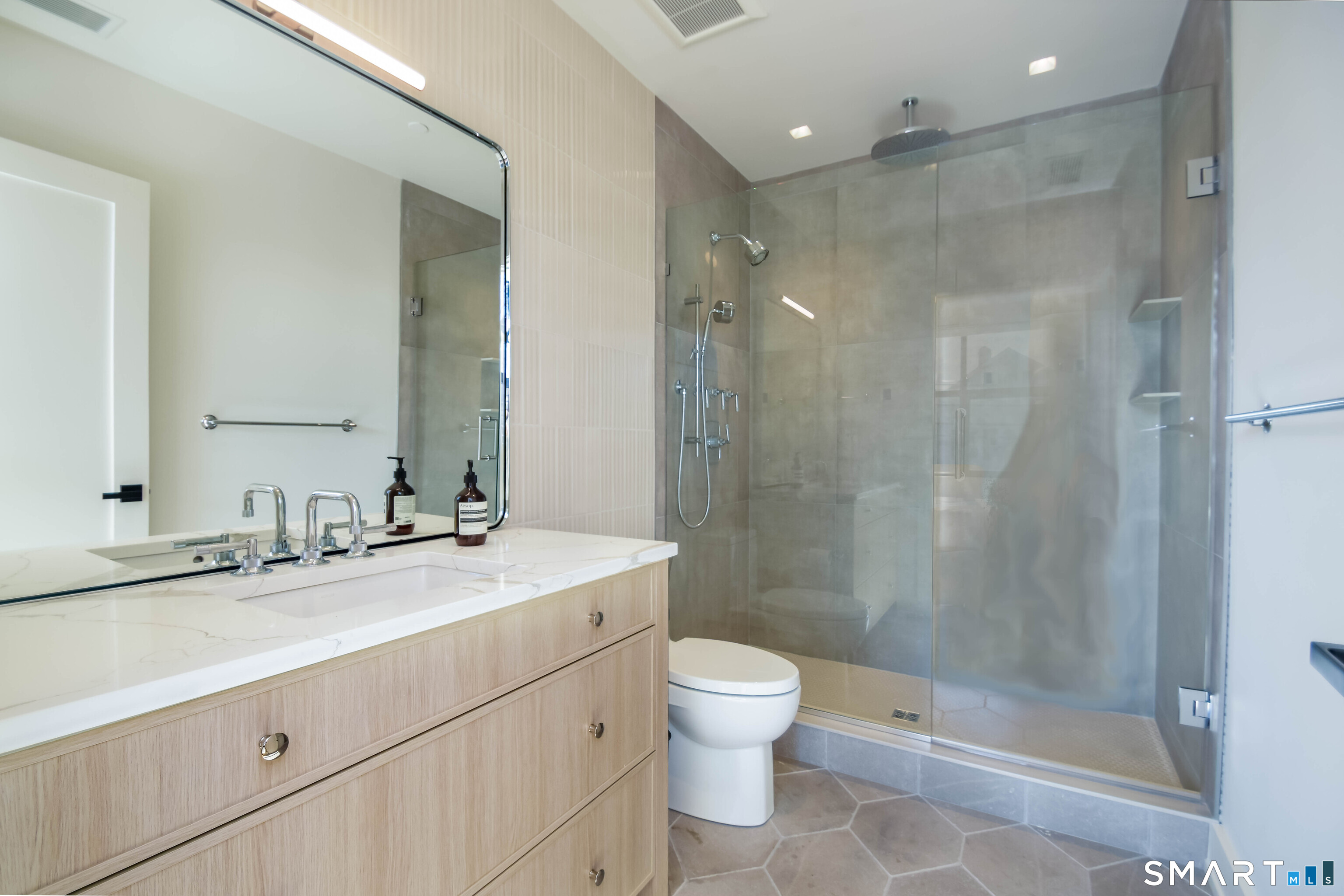 116 Sherman Street, Unit 2 Fairfield, CT 06824 - Photo 23 of 31 a bathroom with a shower sink vanity mirror and toilet