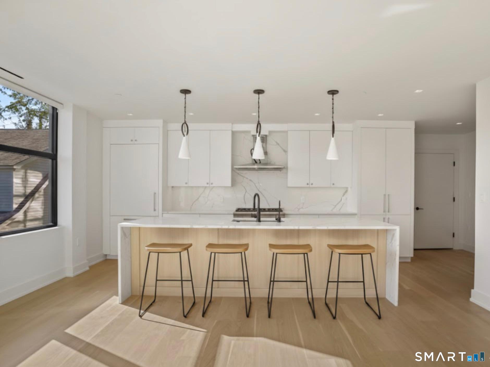 116 Sherman Street, Unit 2 Fairfield, CT 06824 - Photo 26 of 31 a kitchen with a table and chairs in it
