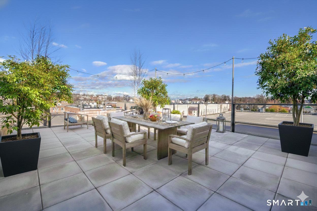 116 Sherman Street, Unit 2 Fairfield, CT 06824 - Photo 30 of 31 a view of a patio with dining table and chairs