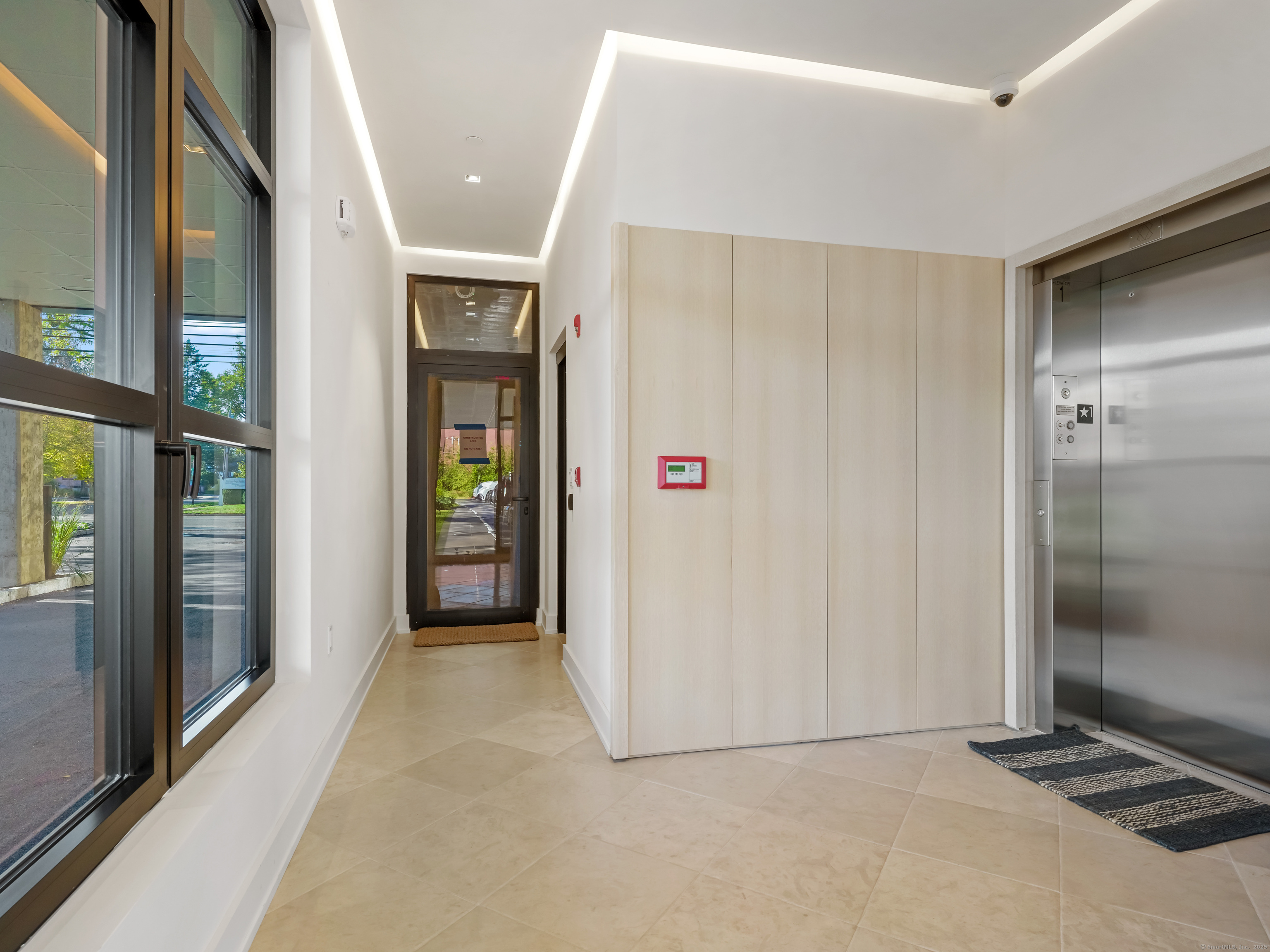 116 Sherman Street, Unit 2 Fairfield, CT 06824 - Photo 7 of 31 a view of a hallway with wooden shelves