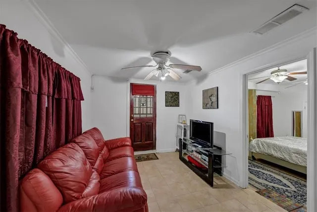 a living room with furniture a flat screen tv and kitchen view