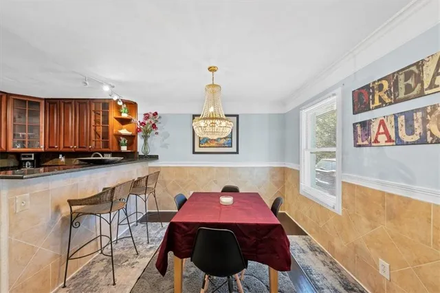 a kitchen with stainless steel appliances kitchen island granite countertop a refrigerator a stove a sink dishwasher with a dining table and chairs