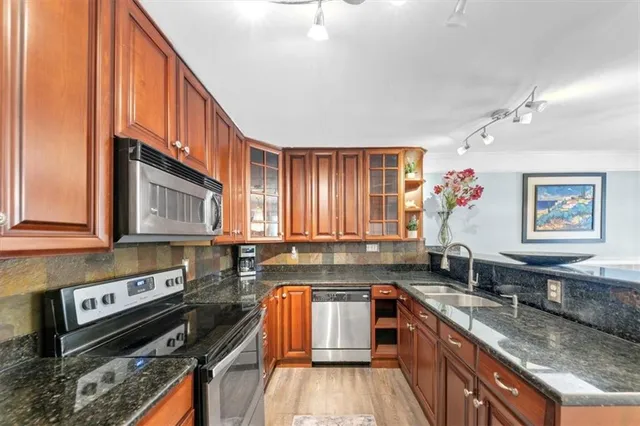 a kitchen with stainless steel appliances granite countertop a stove a sink and cabinets