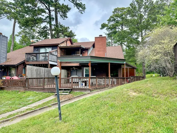 a front view of house with yard and trees in the background