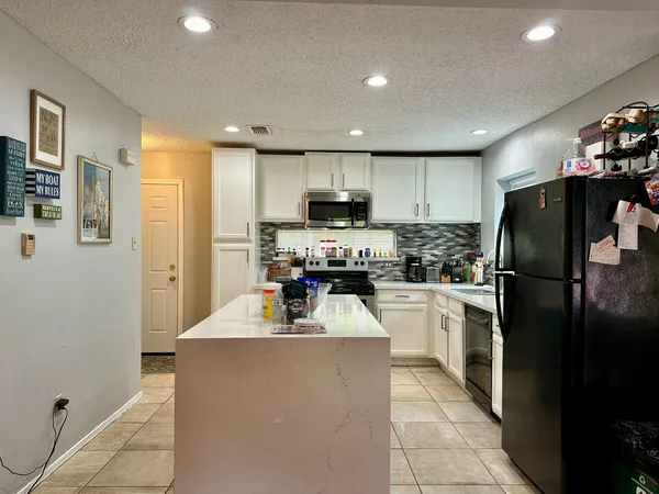 a kitchen with refrigerator and cabinets