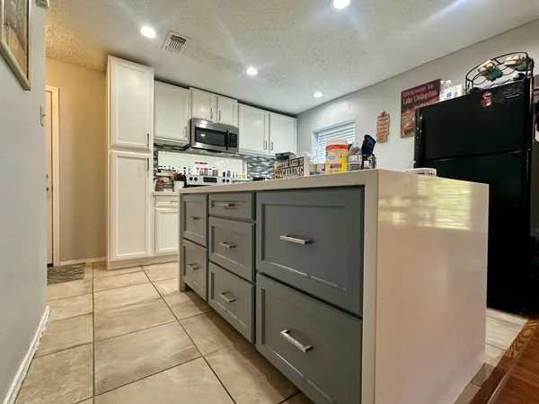 a kitchen with stainless steel appliances granite countertop a refrigerator and a stove top oven