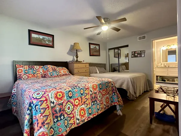 a bedroom with beds and a chandelier