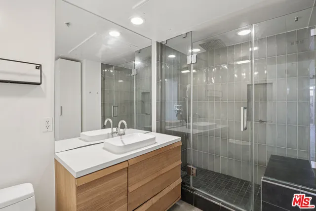 a bathroom with a sink shower and a mirror