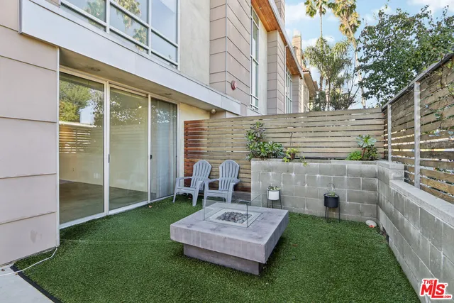a view of a chair and table in backyard of the house