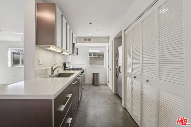 a kitchen with stainless steel appliances granite countertop a sink and dishwasher a refrigerator with wooden floor