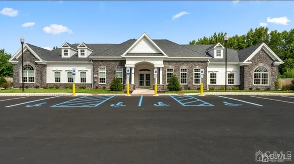 a view of a white house with a large windows and a table and chairs