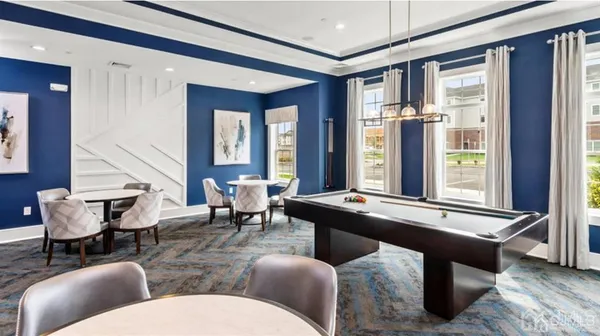 a room with furniture pool table and windows