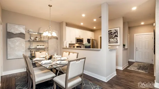 a dining room with stainless steel appliances kitchen island granite countertop furniture and a view of kitchen