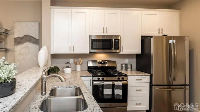 a kitchen with stainless steel appliances granite countertop a refrigerator sink and stove