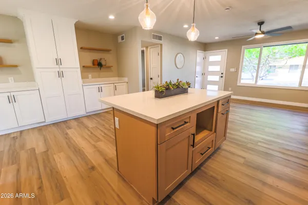 a kitchen that has a lot of cabinets in it and wooden floors