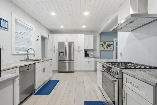 a kitchen with stainless steel appliances a stove a sink and a refrigerator
