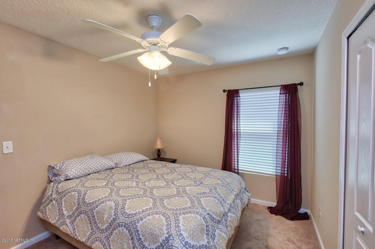 26 North Twin Maple Road St. Augustine, FL 32084 - Photo 21 of 26 a bedroom with a bed and a chandelier