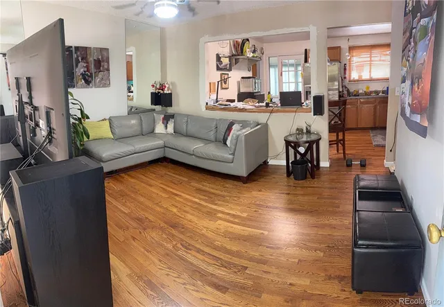 a living room with furniture and a wooden floor