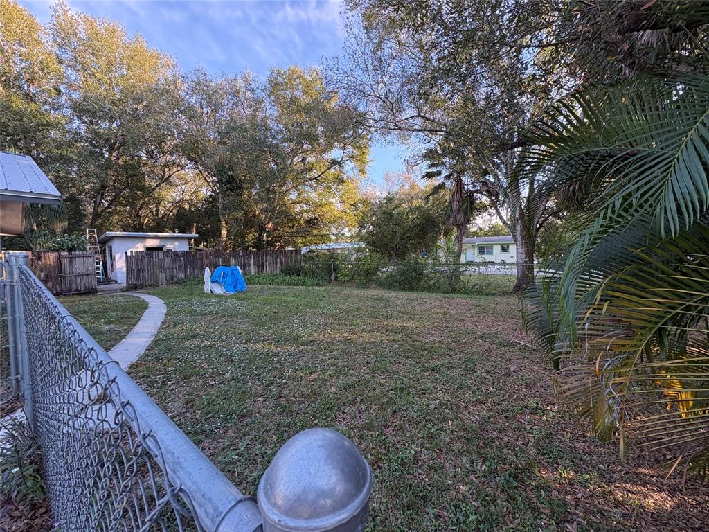 540 Northwest 24th Avenue Okeechobee, FL 34972 - Photo 15 of 24 a view of a backyard with table and chairs under an umbrella