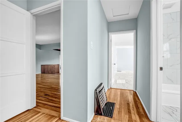 a view of a hallway with wooden floor and staircase