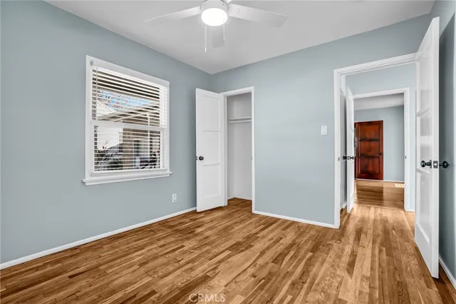 a view of a livingroom with wooden floor and a ceiling fan