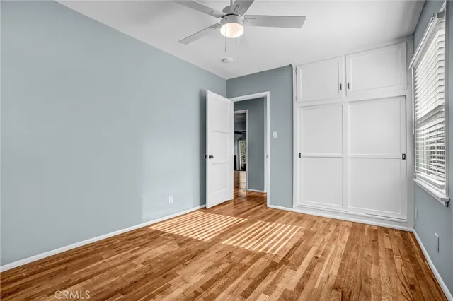 a view of a room with wooden floor and fan