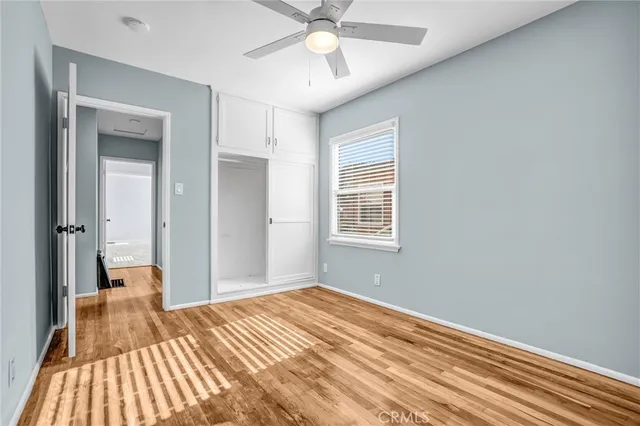 a view of a room with wooden floor and a ceiling fan