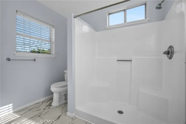 a bathroom with a toilet a sink and a shower