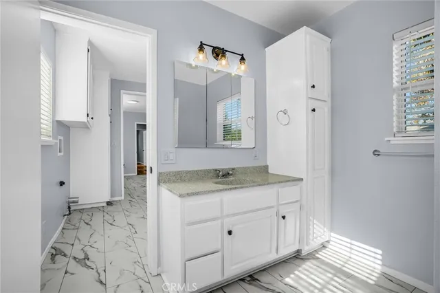 a bathroom with a granite countertop sink and a mirror
