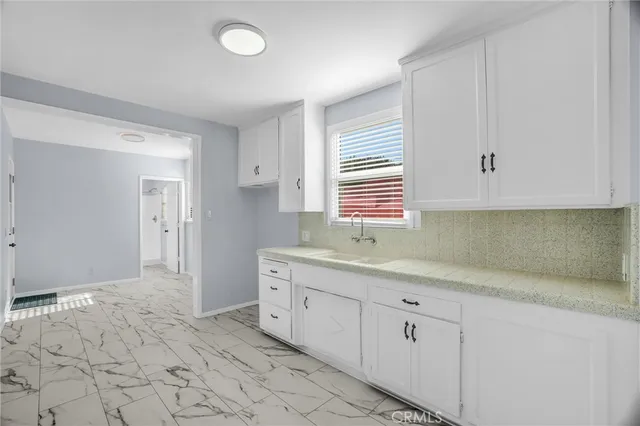 a kitchen with a sink cabinets and window