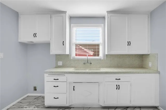 a kitchen with cabinets appliances a sink and a window