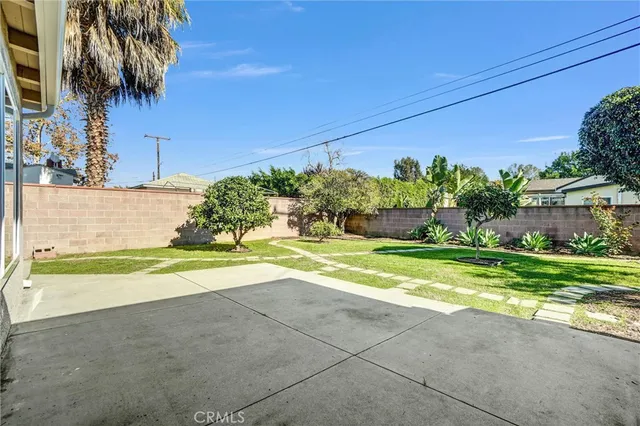 a view of a house with a yard and potted plants
