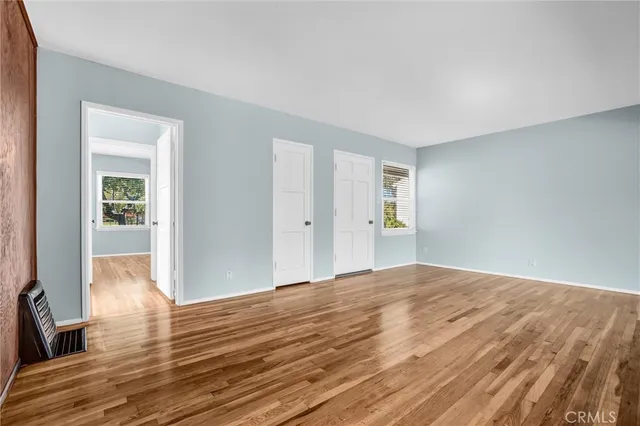 a view of empty room with wooden floor