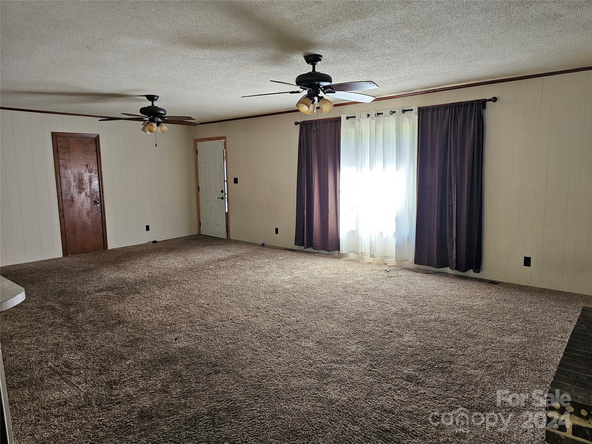 2702 University Drive Lancaster, SC 29720 - Photo 6 of 17 en empty room with windows and fan