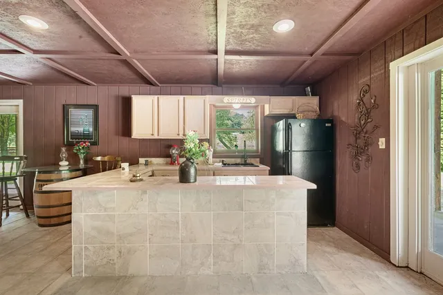 a kitchen with a granite countertop sink and a refrigerator