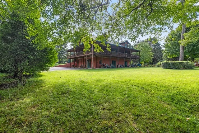 a view of a house with a yard and sitting area