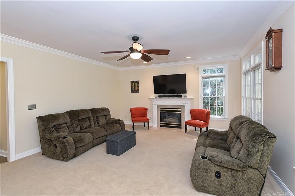 3330 Rhett Butler Place Charlotte, NC 28270 - Photo 16 of 48 a living room with furniture a flat screen tv and a fireplace