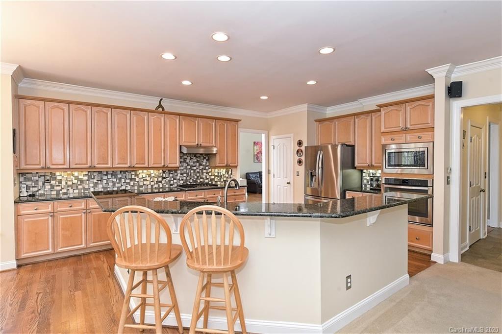 3330 Rhett Butler Place Charlotte, NC 28270 - Photo 18 of 48 a kitchen with stainless steel appliances kitchen island granite countertop a refrigerator and a stove top oven