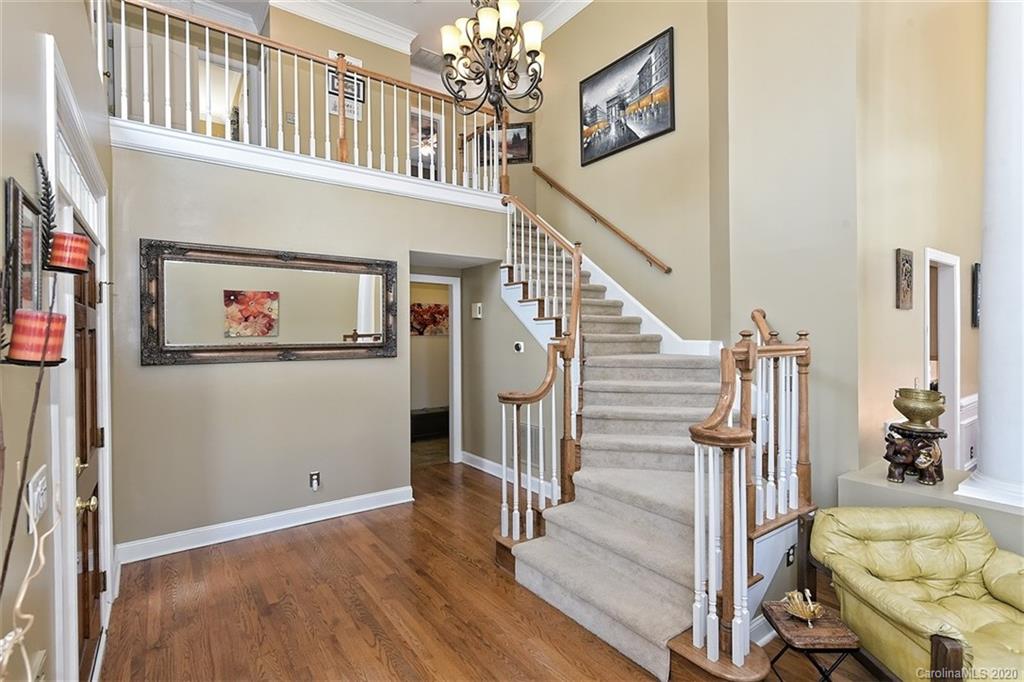 3330 Rhett Butler Place Charlotte, NC 28270 - Photo 6 of 48 a view of staircase with lots of frames on wall and wooden floor