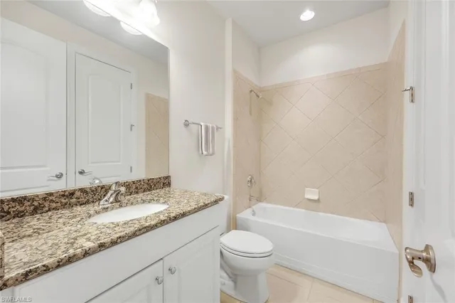 a bathroom with a granite countertop sink a toilet and shower