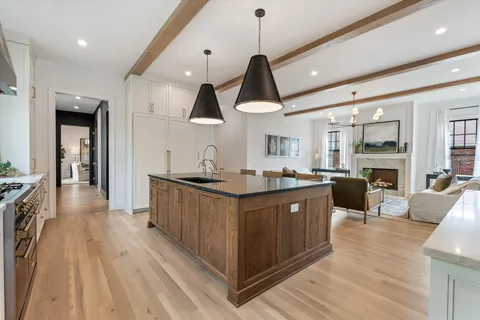 a kitchen with stainless steel appliances granite countertop a refrigerator a sink dishwasher and a large window