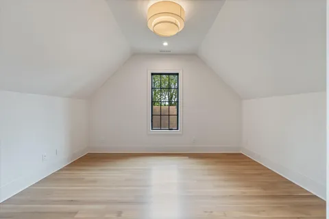 a large kitchen with a refrigerator a sink and a wooden floor