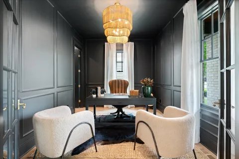 a living room with fireplace furniture and a large window