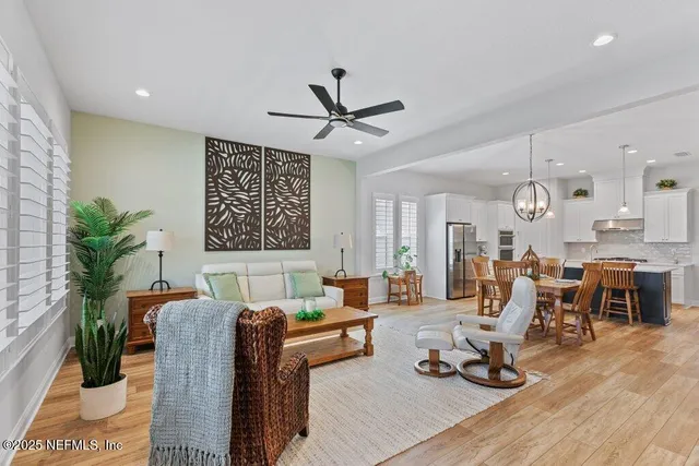 a living room with furniture a flat screen tv and a large window
