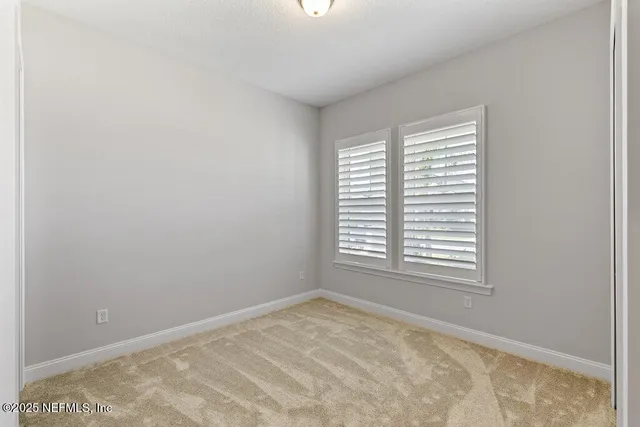 a view of a house with a yard and a large tree front of house