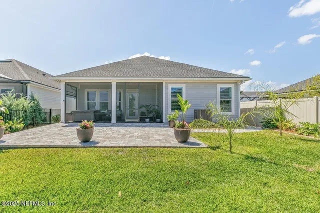 a view of a swimming pool with lawn chairs and a big yard