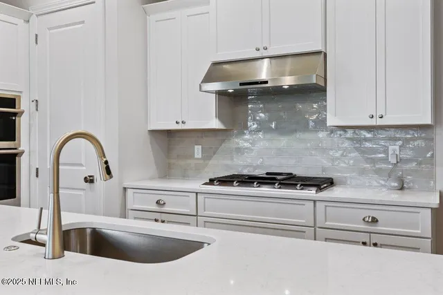 a view of dining room and kitchen with furniture wooden floor and a chandelier