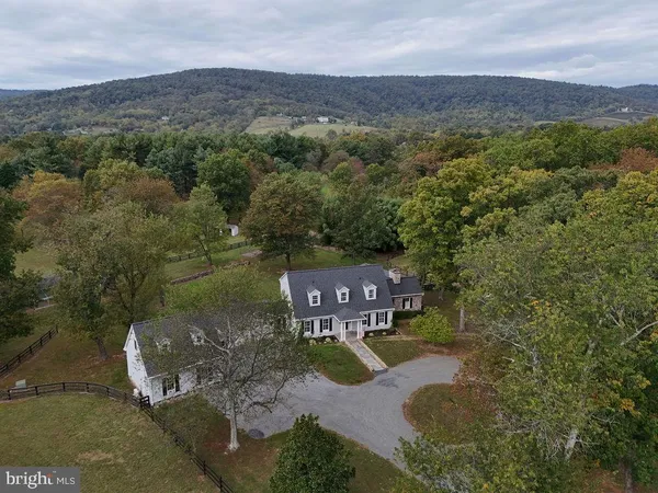 an aerial view of residential houses with outdoor space and trees